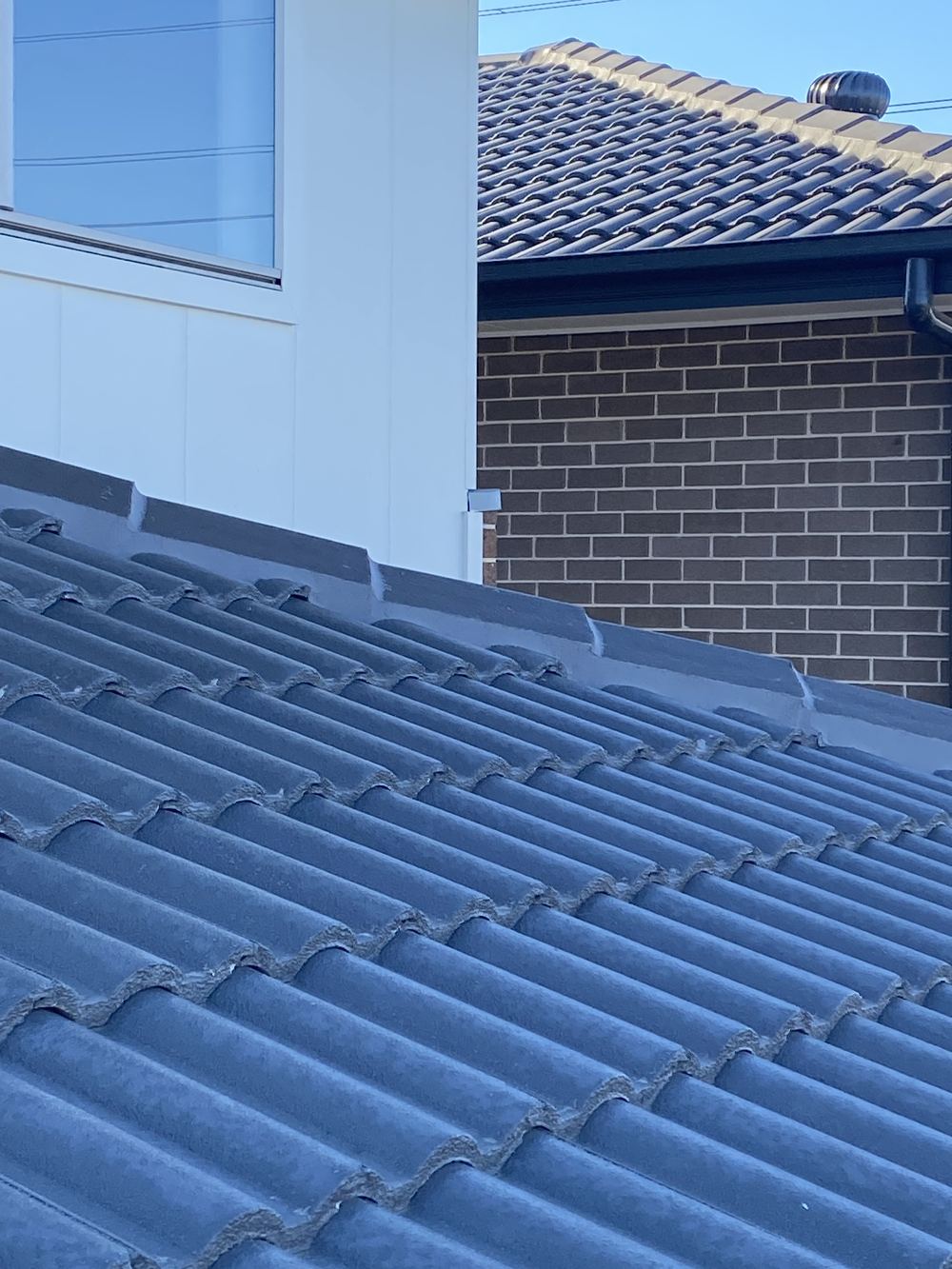 Parapet capping falling the wrong way, sending water back over the wall, found during a handover inspection in Gables