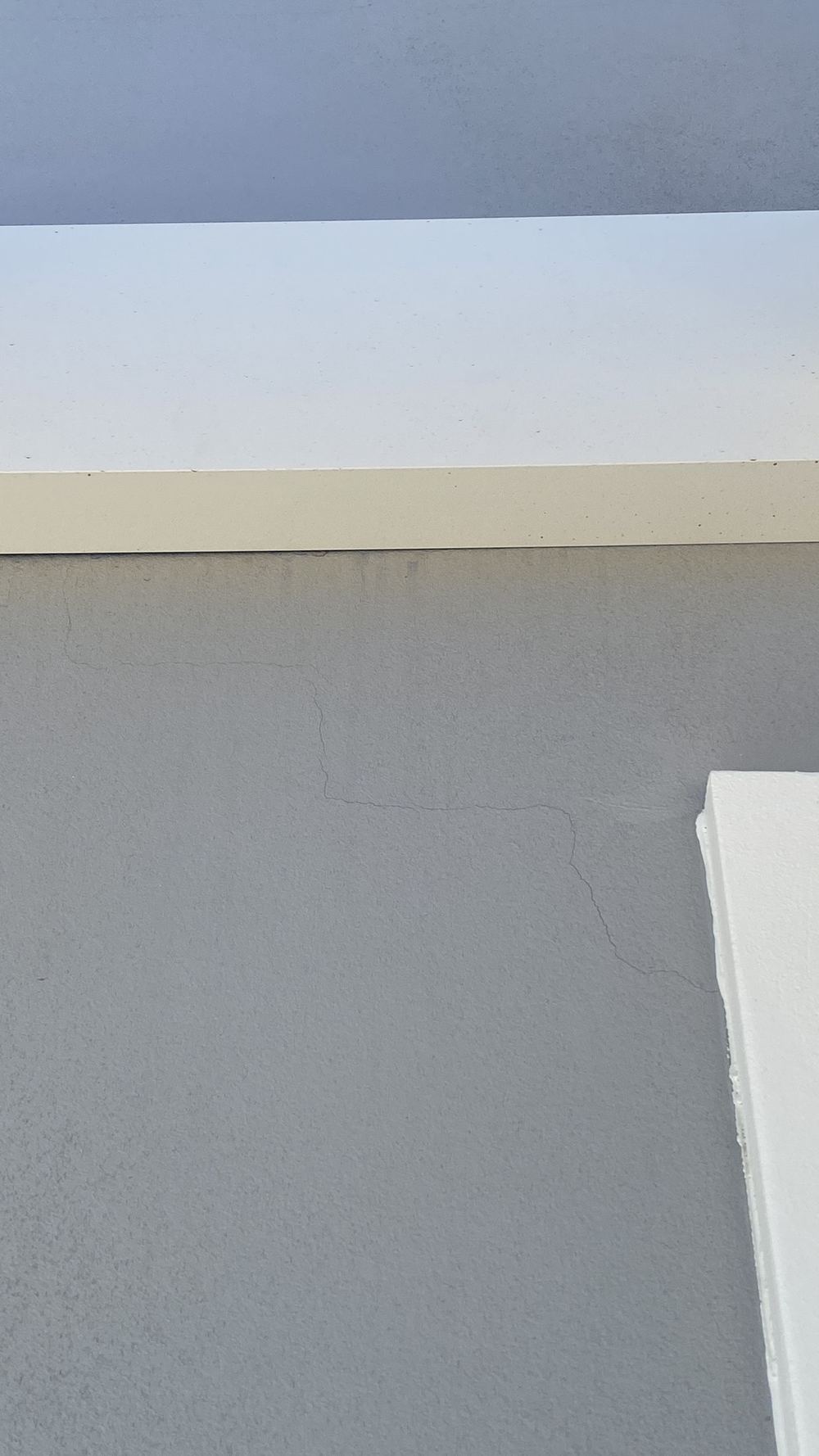 Step cracking in new brickwork at the corner of a front window, found during a handover inspection in Gables